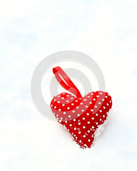Red Spotty Heart laying in the cold winter snow