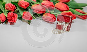 Red spring tulips with small box with pearls romantic present