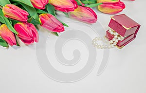 Red spring tulips with small box with pearls romantic present