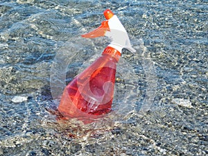 A red sprinkler bottle in the sea