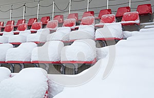 Red stadium seats covered in snow.