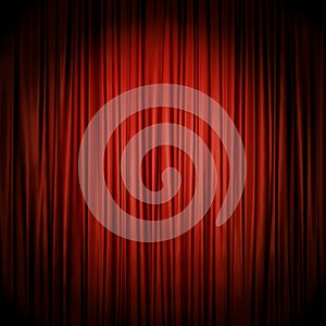Red stage curtain illuminated by spotlight