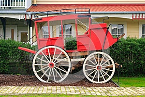 Red stagecoach in front of historic buildings