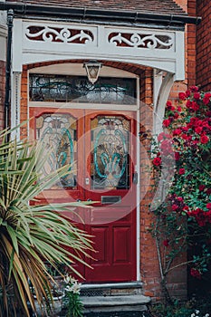 Red stained glass front door on an Edwardian house in London, UK