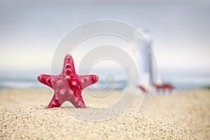 A red starfish and lighthouse at the beach.