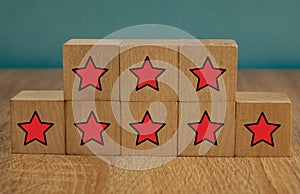 Red stars on wooden cubes on a blue background. Stars mean assessing quality. five-point rating system