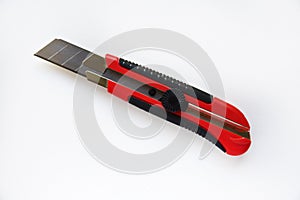 Red stationery knife with blades on a white background. Cutting tool with blades on a white background