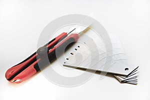 Red stationery knife with blades on a white background. Cutting tool with blades on a white background