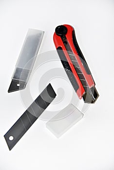 Red stationery knife with blades on a white background. Cutting tool with blades on a white background