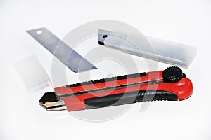 Red stationery knife with blades on a white background. Cutting tool with blades on a white background