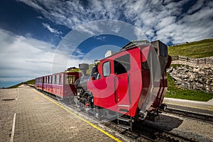 Red steam historic locomotive waiting in Schafbergspitze station near Salzburg