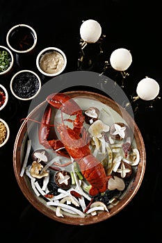 Red steamed lobster with mushroom in plate on black background