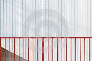 Red steel bar fence and white stripped wall