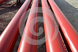 Red steel pipes for fire fighting system and extinguishing water lines in industrial building. Paint shop. Steel pipe painted red