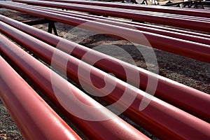 Red steel pipes for fire fighting system and extinguishing water lines in industrial building. Paint shop. Steel pipe painted red