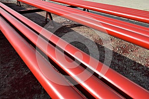 Red steel pipes for fire fighting system and extinguishing water lines in industrial building. Paint shop. Steel pipe painted red