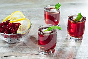 Red stemware shot alcoholic cold cocktail with cranberries raspberries lemon and mint. Selective focus, copy space