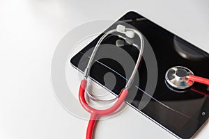 Red stethoscope on black tablet device shows health records and digital patient records on cloud data security for digital doctors