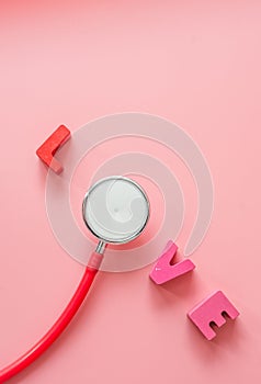 Red Stethoscope with love on pink background.