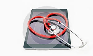 Red stethoscope rolled in the shape of a heart on a tablet on a white background with copyspace. Concept of technology and