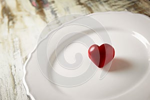 A red stone heart in a white plate