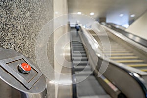 red STOP button to turn off the movement of escalators on a subway station platform.