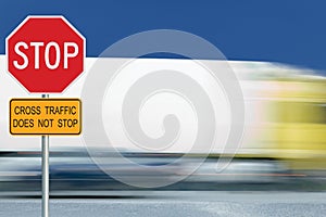 Red stop road sign, motion blurred truck vehicle traffic in background, regulatory warning signage octagon, white octagonal frame