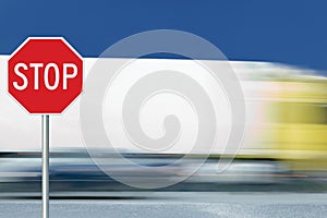 Red stop road sign, motion blurred truck vehicle traffic in background, regulatory warning signage octagon, white octagonal frame
