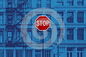 Red stop sign against blue background of buildings in Manhattan, New York City