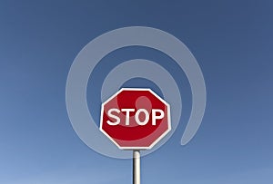 Red stop sign and blue sky.