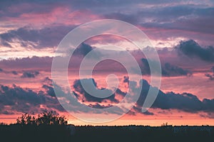 red storm clouds over meadow with green grass - vintage effect