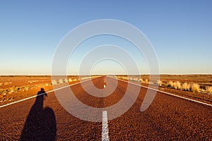 red straight road with red dessert on the Stuart Highway north of copper pedy, South Australia