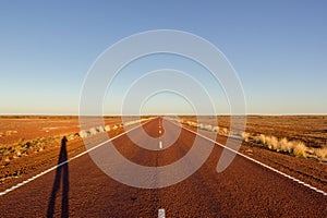 red straight road with red dessert on the Stuart Highway north of copper pedy, South Australia