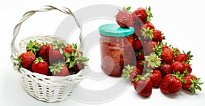 Red strawberries in the basket and on the table isolated on white