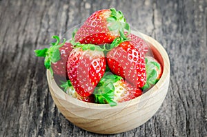 Red Strawberries in brown wooden bowl