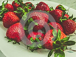 Red strawberries lie on a white table. Delicious, bright, sweet, healthy, vitamin strawberry.