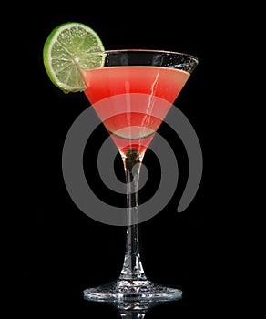 Red strawberry cocktail decorated with lime in martini