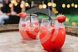 Red strawberry daiquiri cocktail or mocktail in glass with drinking straw. Refreshing summer drink for party or festive