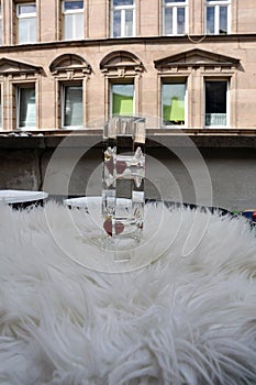 A red strawberry in a glass decorative vertical installation. Blurred industrial glass background