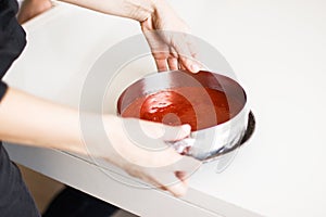 Red strawberry jelly with fruit piece in a plastic cup placed on its side with clipping path.