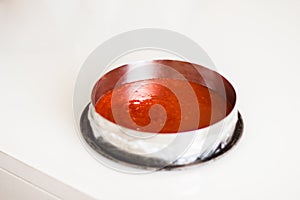 Red strawberry jelly with fruit piece in a plastic cup placed on its side with clipping path.