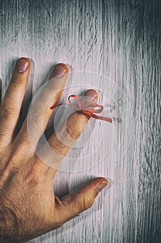 Red String Tied Around a Finger. Memory and Reminder Knot