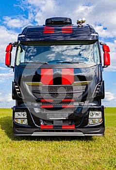 Red striped big rig on grass
