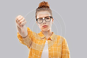 Red student girl in glasses showing thumbs down