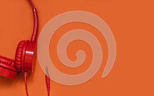 Red stylish headphones on an orange background