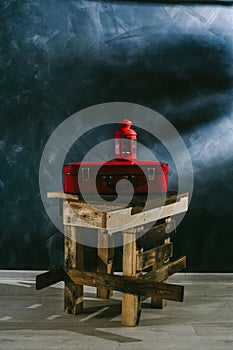 A red suitcase and a red candlestick on a dark background