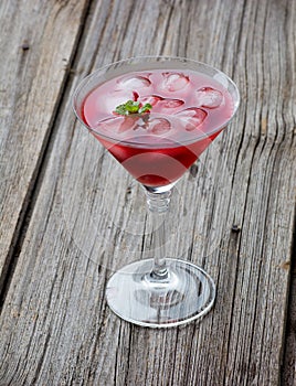 Red Summer martini drink with mint on wooden