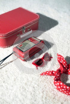 Red summer vacation lugagge displayed on white carpet floor. photo