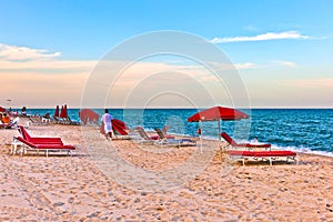 Red sunloungers and parasols at the beach photo