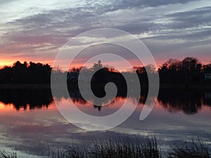 Red sunset reflected over tranquil pond